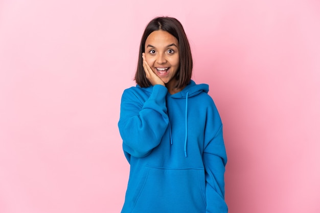 Jeune femme latine isolée sur un mur rose avec surprise et expression faciale choquée