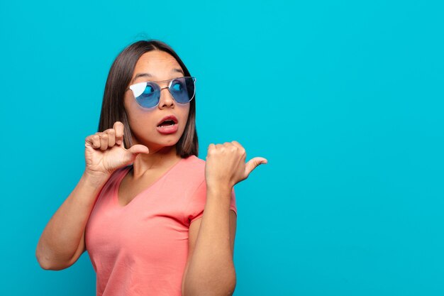 Jeune femme latine avec des lunettes de soleil et un espace de copie