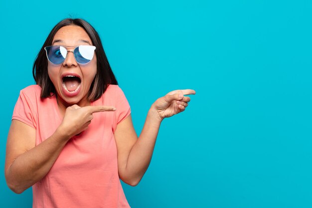 Jeune femme latine avec des lunettes de soleil et un espace de copie