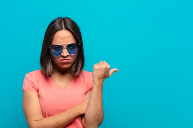 Jeune femme latine avec des lunettes de soleil et un espace de copie