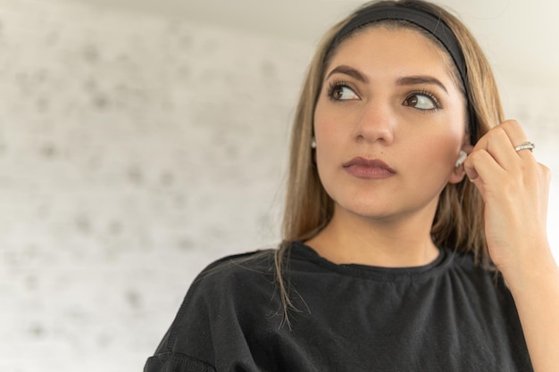 Photo une jeune femme latine met ses écouteurs sans fil.