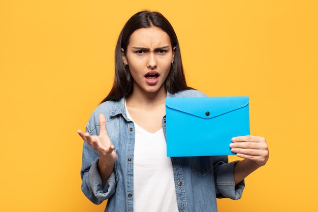 Jeune femme latine à la recherche désespérée et frustrée, stressée, malheureuse et agacée, criant et hurlant