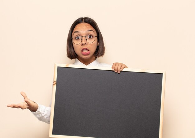 Jeune femme latine se sentant extrêmement choquée et surprise, anxieuse et paniquée, avec un regard stressé et horrifié