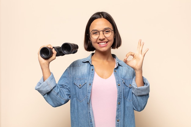 Jeune femme latine se sentant heureuse, détendue et satisfaite, montrant son approbation avec un geste correct, souriant