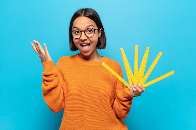 Jeune femme latine se sentant heureuse, excitée, surprise ou choquée, souriante et étonnée de quelque chose d'incroyable