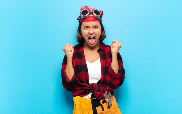 Jeune femme latine se sentant heureuse, surprise et fière, criant et célébrant le succès avec un grand sourire