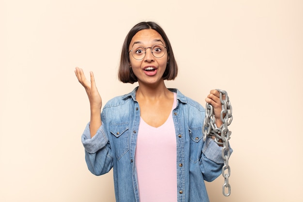 Jeune femme latine se sentant heureuse, surprise et joyeuse, souriant avec une attitude positive, réalisant une solution ou une idée