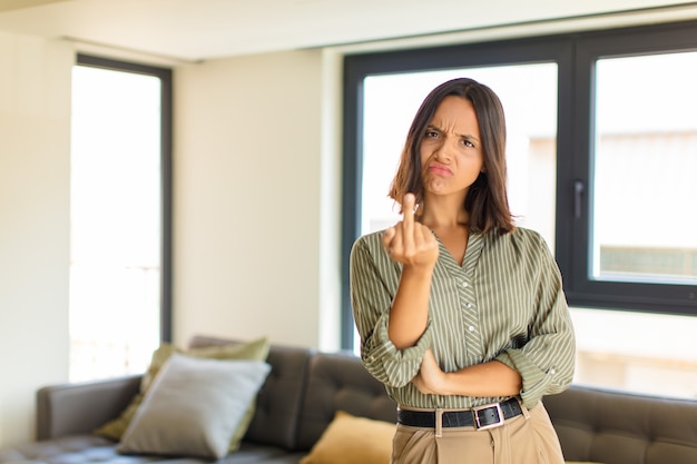 Jeune femme latine se sentir en colère, ennuyé, rebelle et agressif, retournant le doigt du milieu, ripostant