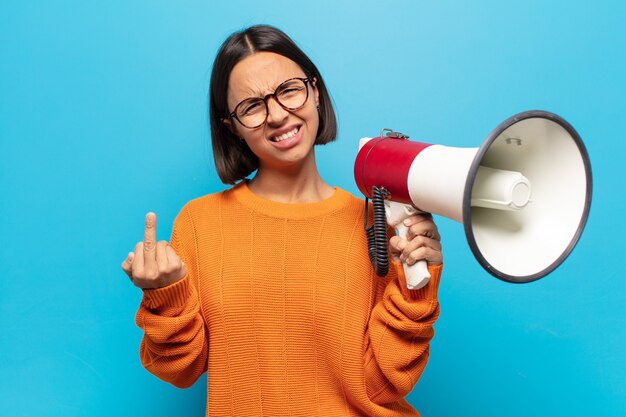 jeune femme latine se sentir en colère, ennuyé, rebelle et agressif, en retournant le majeur, en ripostant