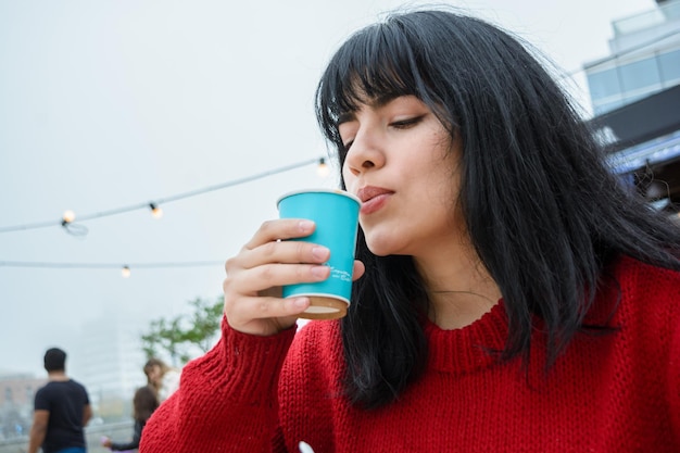 jeune femme latine soufflant sur le café parce qu'il fait trop chaud pour boire