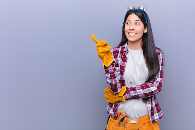 Jeune femme latine souriant joyeusement et regardant de côté, se demandant, pensant ou ayant une idée