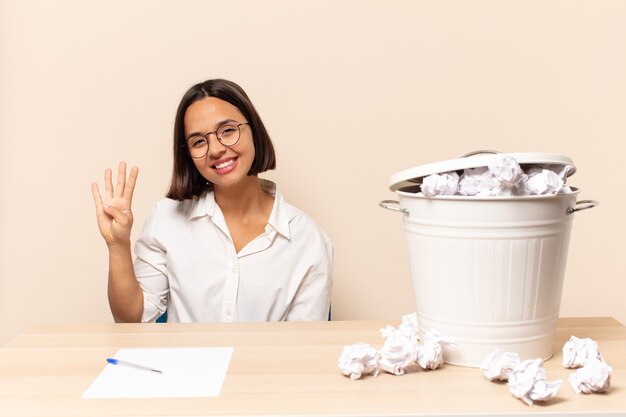 Jeune femme latine souriante et à la convivialité, montrant le numéro quatre ou quatrième avec la main en avant, compte à rebours