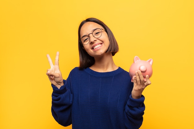 Jeune femme latine souriante et à la sympathique, montrant le numéro deux ou seconde avec la main en avant, compte à rebours