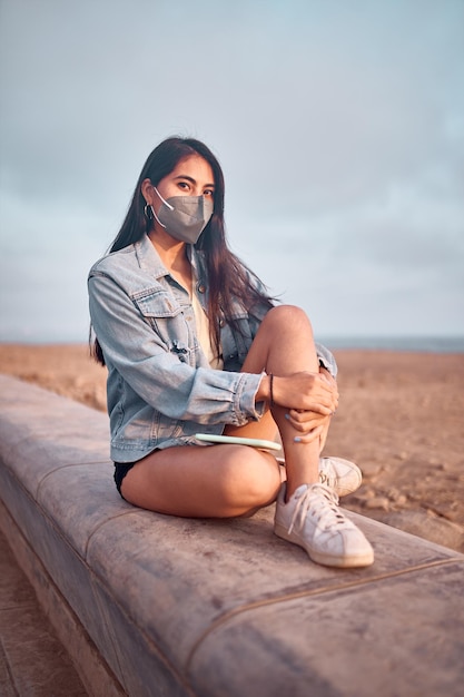 Jeune femme latine sourit pendant un beau coucher de soleil Heureuse jeune femme avec masque