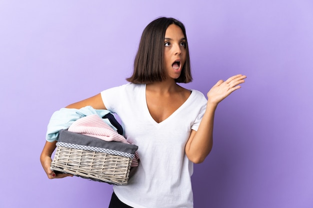 Jeune femme latine tenant un panier de vêtements