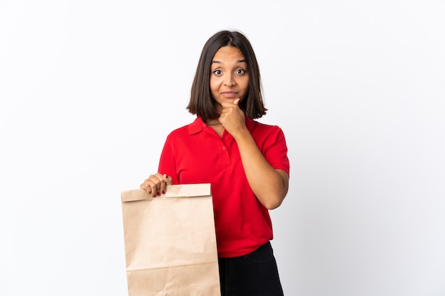 Jeune femme latine tenant un sac d'épicerie