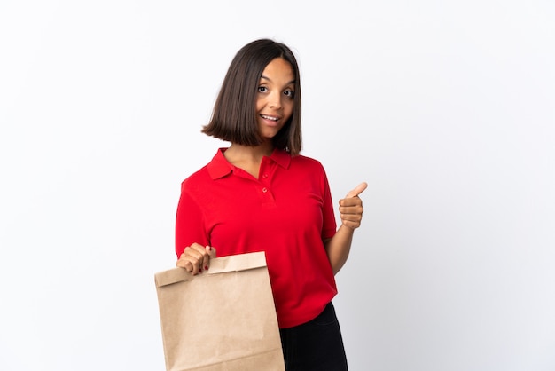 Jeune femme latine tenant un sac d'épicerie