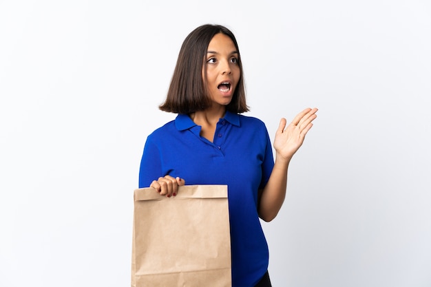 Jeune femme latine tenant un sac d'épicerie