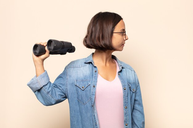 Jeune femme latine sur la vue de profil à la recherche de copier l'espace à venir, penser, imaginer ou rêver