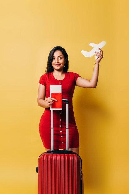 Jeune femme latinx tenant un concept de mouche d'avion en papier