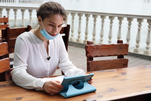 Jeune femme, lecture, sur, tablette, séance table, dans, rue café