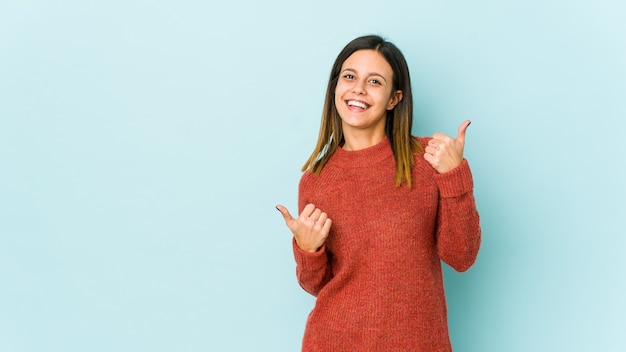 Jeune femme levant les deux pouces vers le haut, souriante et confiante.