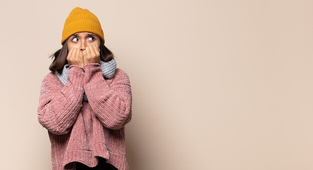 Jeune femme levant les mains à la tête, bouche bée, se sentant extrêmement chanceux, surpris, excité et heureux