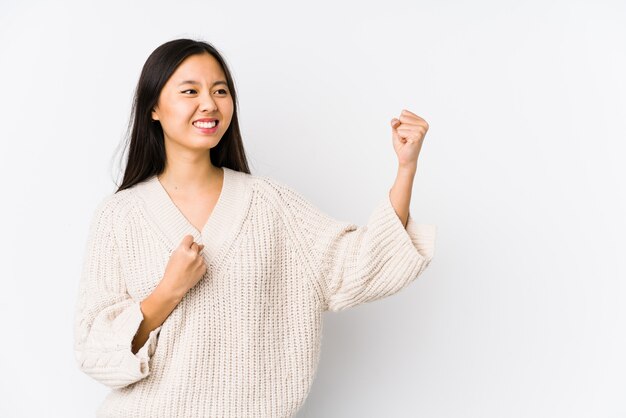 Jeune femme levant le poing après une victoire, concept gagnant.