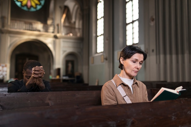 Photo jeune femme lisant la bible dans l'église