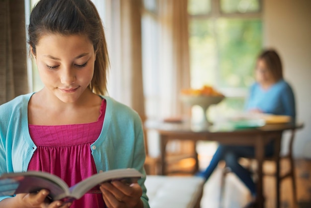 Une jeune femme lisant un livre dans une maison meublée de façon traditionnelle