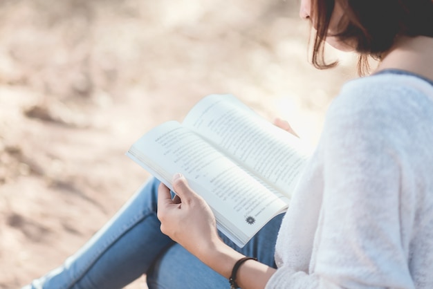 Une jeune femme lisant un livre. Livre dans les mains de la femme