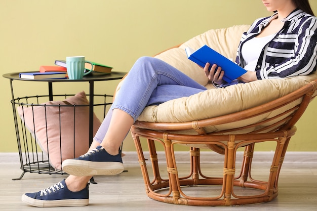 Jeune femme lisant un livre à la maison