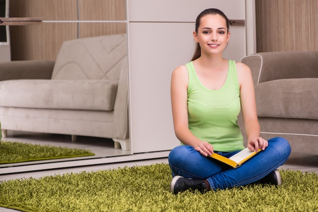 Jeune femme lisant des livres à la maison