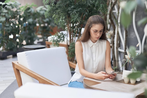 Jeune femme lisant son e-mail dans un café