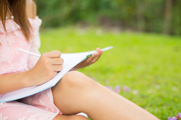 Jeune femme lit un livre dans une fille publique.