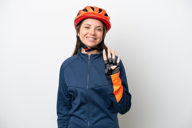 Jeune femme lituanienne cycliste isolée sur fond blanc heureuse et comptant quatre avec les doigts