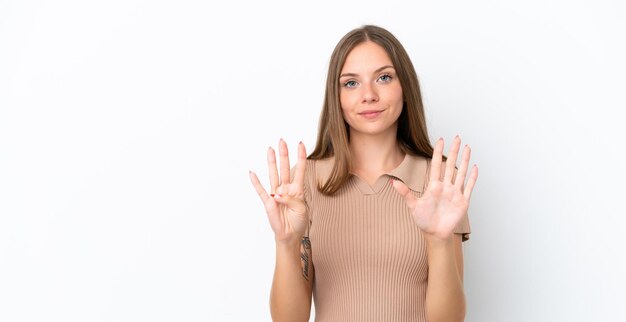 Jeune femme lituanienne isolée sur fond blanc comptant neuf avec les doigts