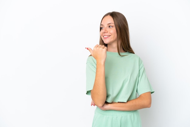 Jeune femme lituanienne isolée sur fond blanc pointant vers le côté pour présenter un produit