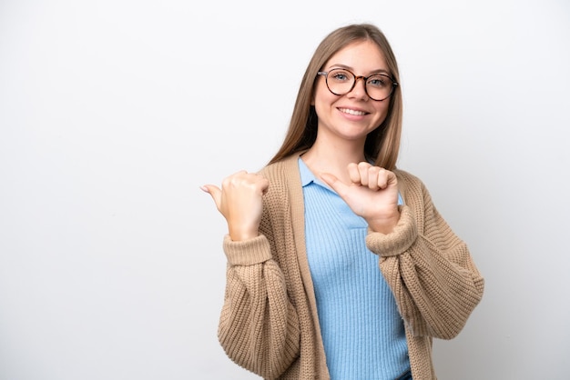 Jeune femme lituanienne isolée sur fond blanc pointant vers le côté pour présenter un produit