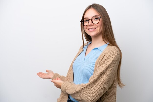 Jeune femme lituanienne isolée sur fond blanc tendant les mains sur le côté pour inviter à venir