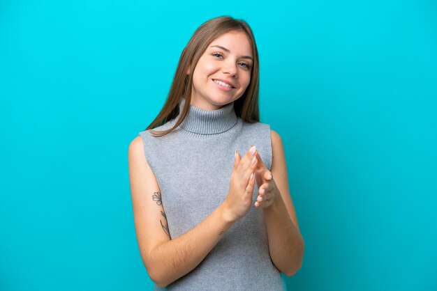 Jeune femme lituanienne isolée sur fond bleu applaudissant après présentation lors d'une conférence