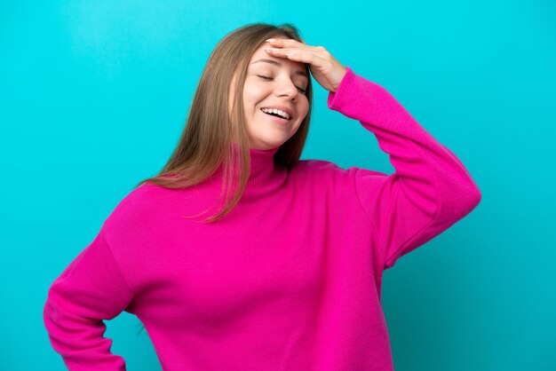 Jeune femme lituanienne isolée sur fond bleu souriant beaucoup