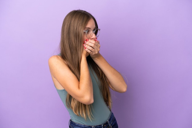 Jeune femme lituanienne isolée sur fond violet couvrant la bouche et regardant sur le côté