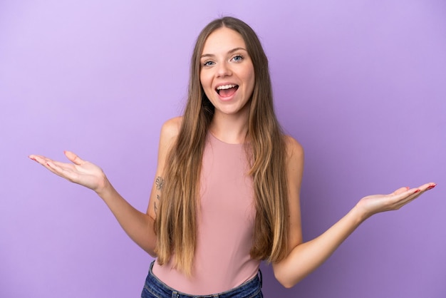 Jeune femme lituanienne isolée sur fond violet avec une expression faciale choquée