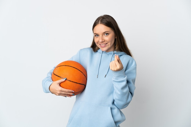 Jeune femme lituanienne jouant au basket isolé sur fond blanc faisant le geste de l'argent