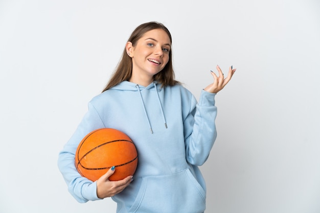 Jeune femme lituanienne jouant au basket isolé sur un mur blanc étendant les mains sur le côté pour inviter à venir