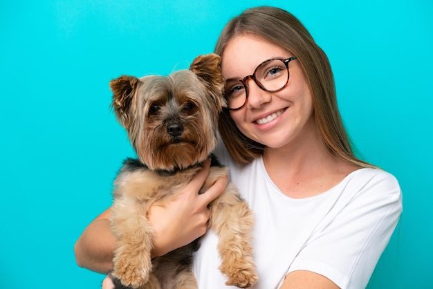 Jeune femme lituanienne tenant un chien isolé sur fond bleu