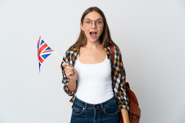 Jeune femme lituanienne tenant un drapeau du Royaume-Uni isolé sur fond blanc avec une expression faciale surprise