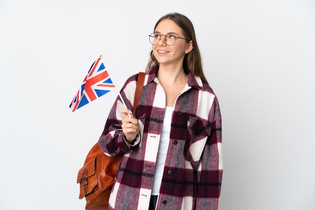 Jeune femme lituanienne tenant un drapeau du Royaume-Uni isolé sur fond blanc en pensant à une idée tout en regardant