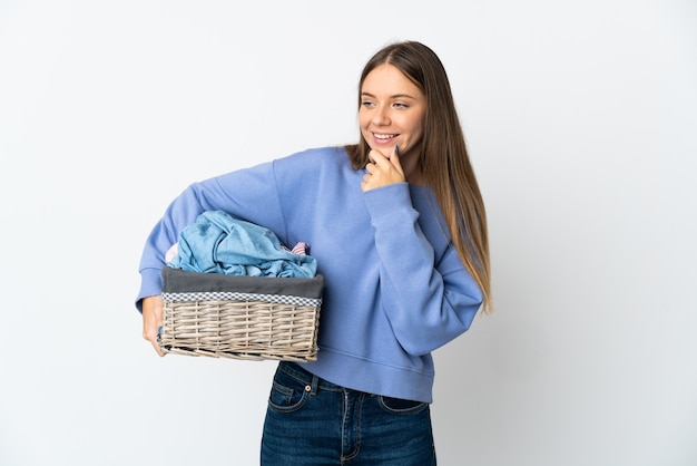 Jeune femme lituanienne tenant un panier de vêtements isolé sur fond blanc